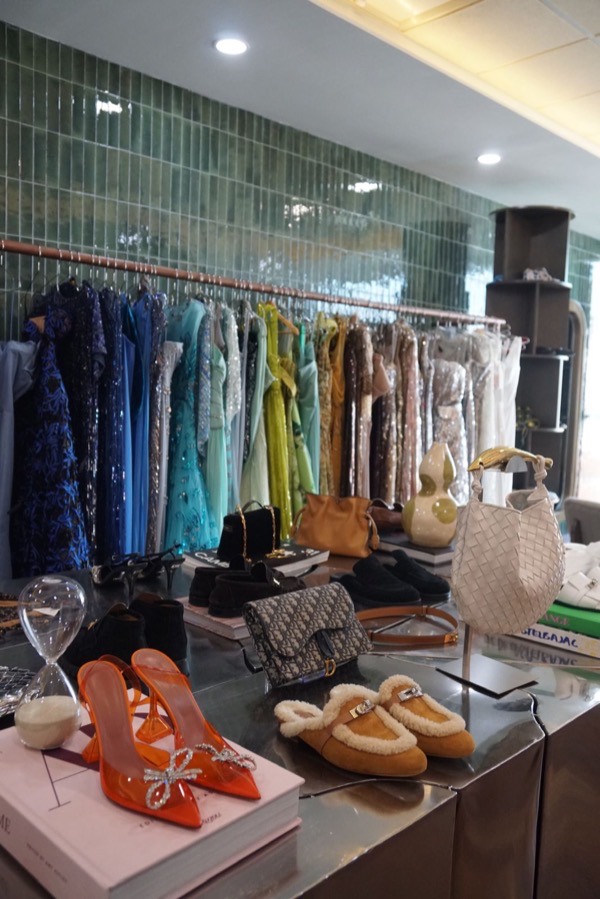 Dresses by colour, with bags and shoes on the display table